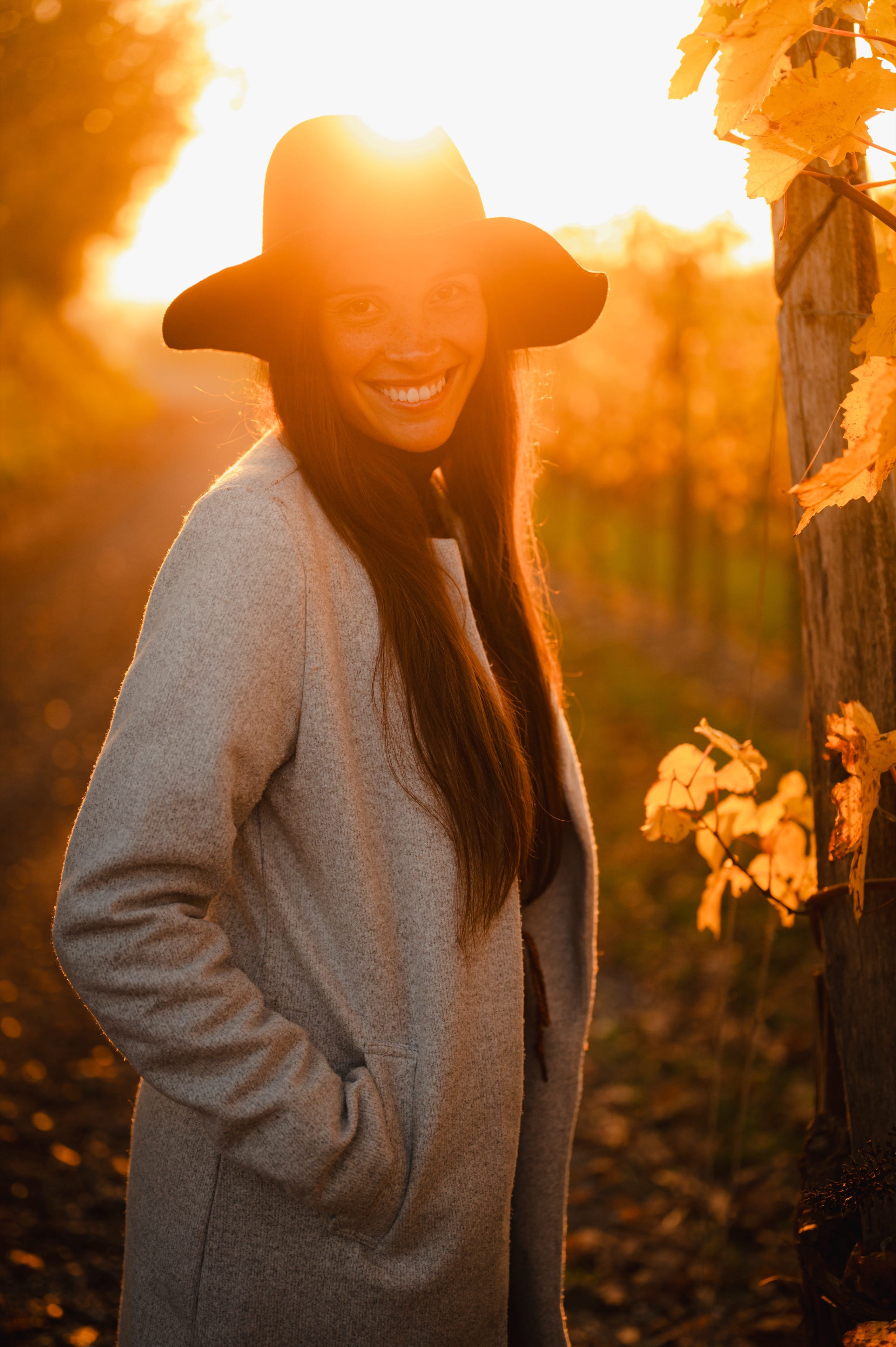 Portrait einer jungen Frau mit Hut in einem Weingarten