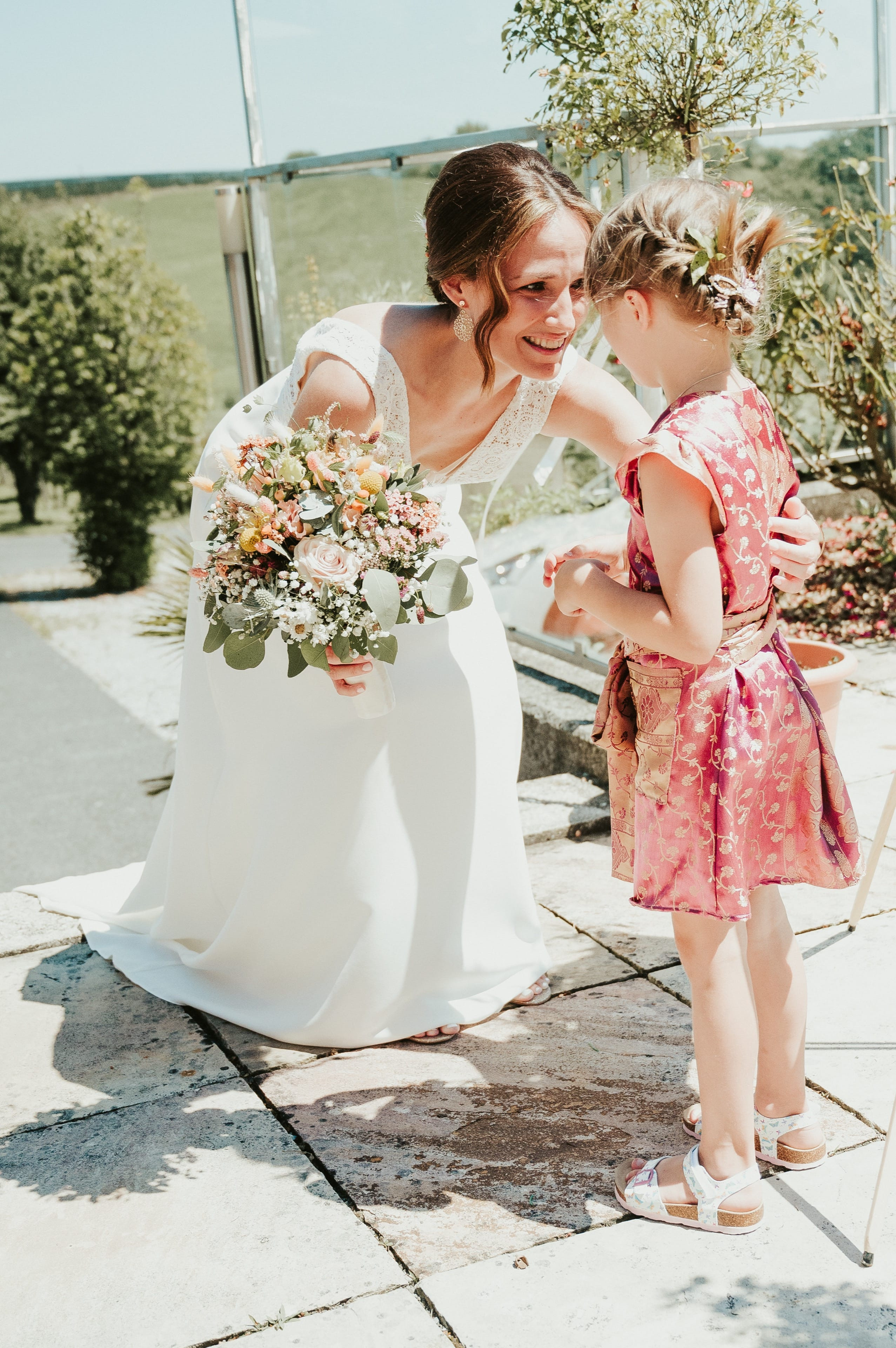 Eine Braut die sich bei ihrem Blumenmädchen für den Brautstrauß bedankt